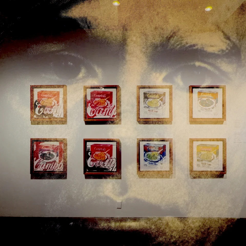 Framed artwork layered with warm reflections.