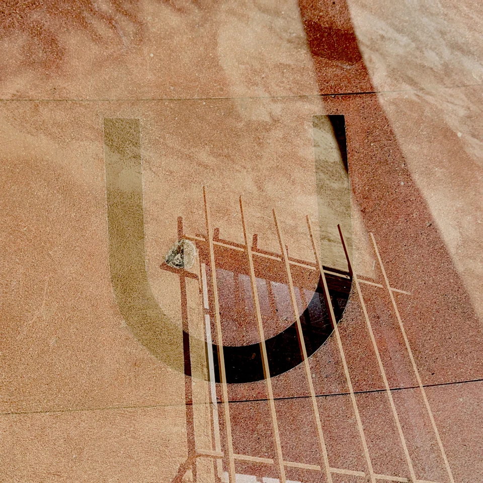 Guitar strings layered with warm peach surfaces and lettering.
